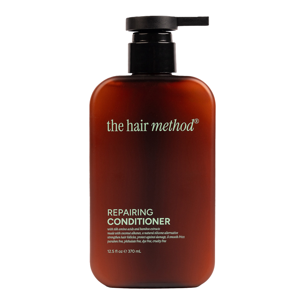 Brown bottle of 'the hair method' repairing conditioner on a white background