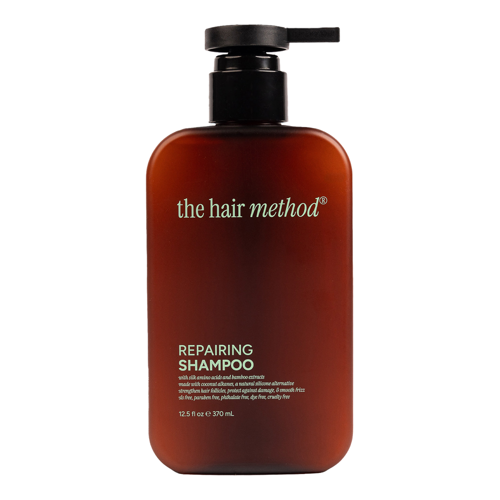Brown shampoo bottle with black pump labeled 'the hair method' on a white background
