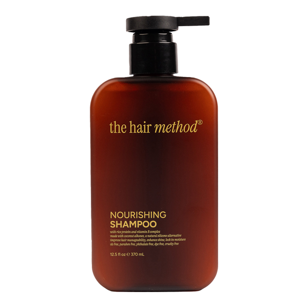 Brown shampoo bottle with pump labeled 'the hair method' on a white background