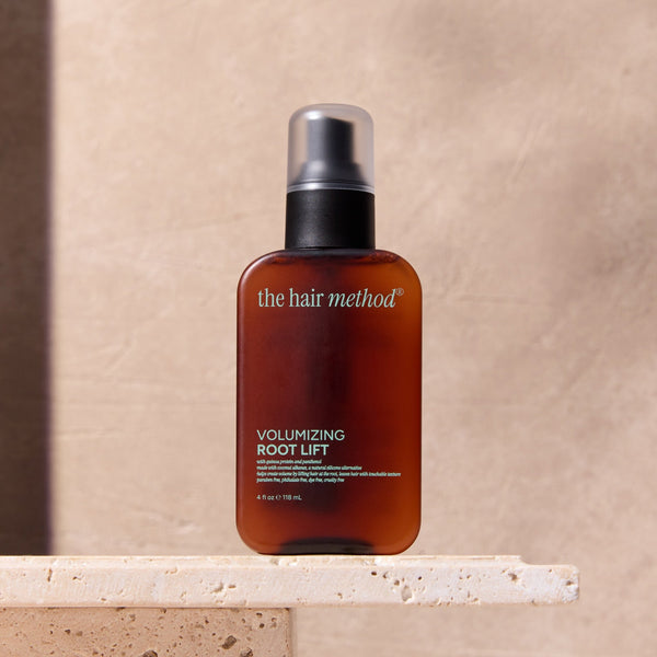 Bottle of 'The Hair Method' volumizing root lift on a stone surface with a neutral background